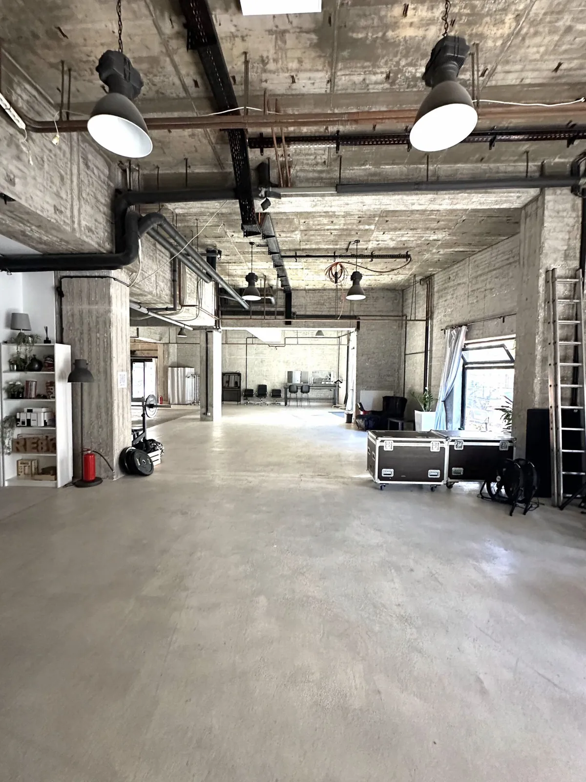 Die offene Studiohalle von qre8.studio mit Sichtbeton und Tageslicht